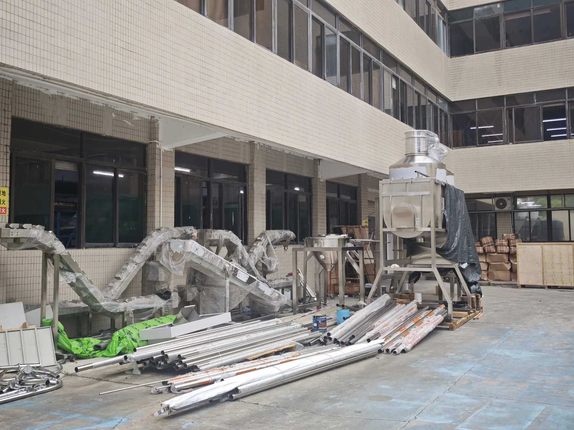 Packaging line equipment and stainless steel parts staged in the LEKA factory assembly area