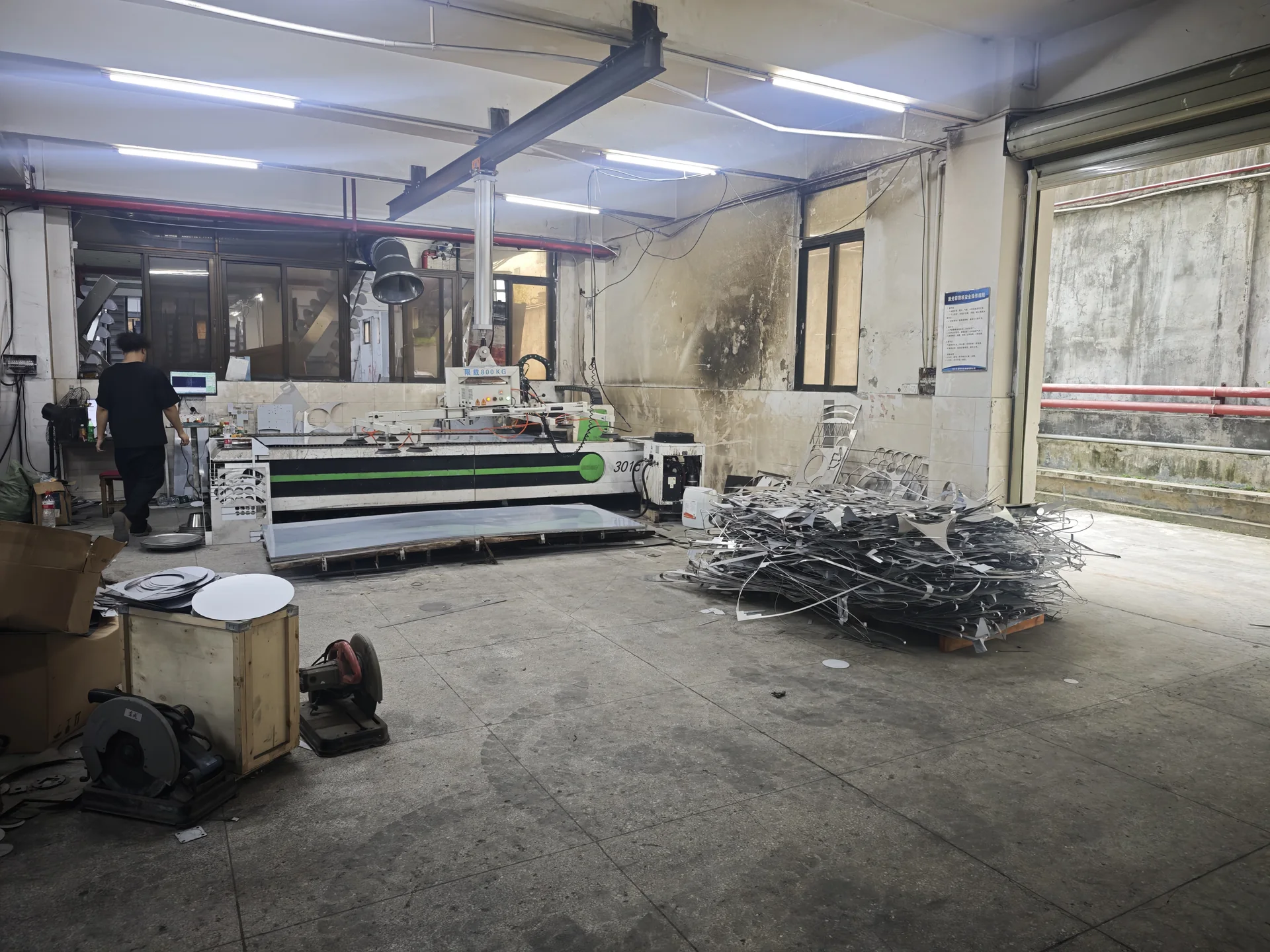Operator preparing sheet metal parts on laser cutting equipment in the LEKA factory