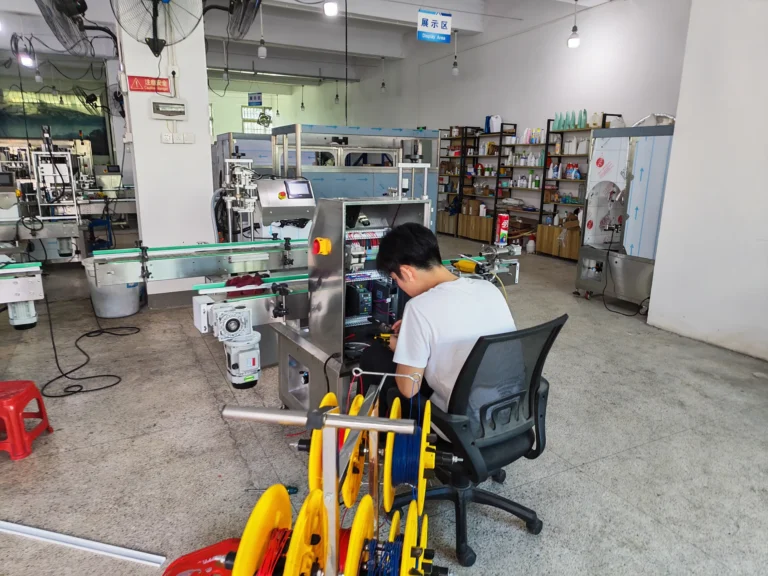 Technician connecting wiring inside a packaging line control cabinet
