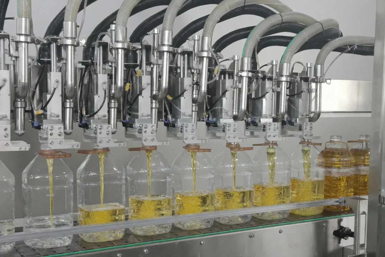 Multi-head filling machine dosing edible oil into clear bottles